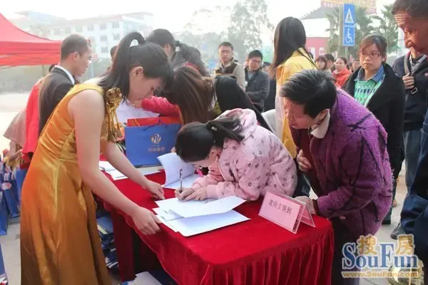 堆满了一份份精美礼品,桌面也叠放着序号卡,老业主签到领取精美礼品