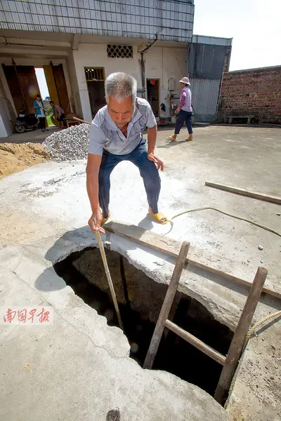 上垌村民周承希用10米长的竹竿探了下院子里的深坑，但整根竹竿伸了进去，还探不到底。