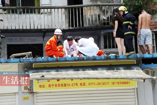 消防和医务人员爬上铁棚进行救援