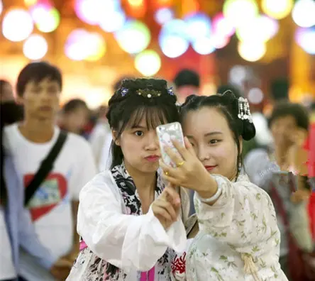 两位身着汉服的女孩在古南门前开心自拍。