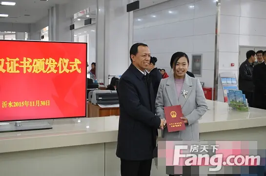 省政府副省长王书坚(左)，为张洁颁发山东省县级首本不动产权证书